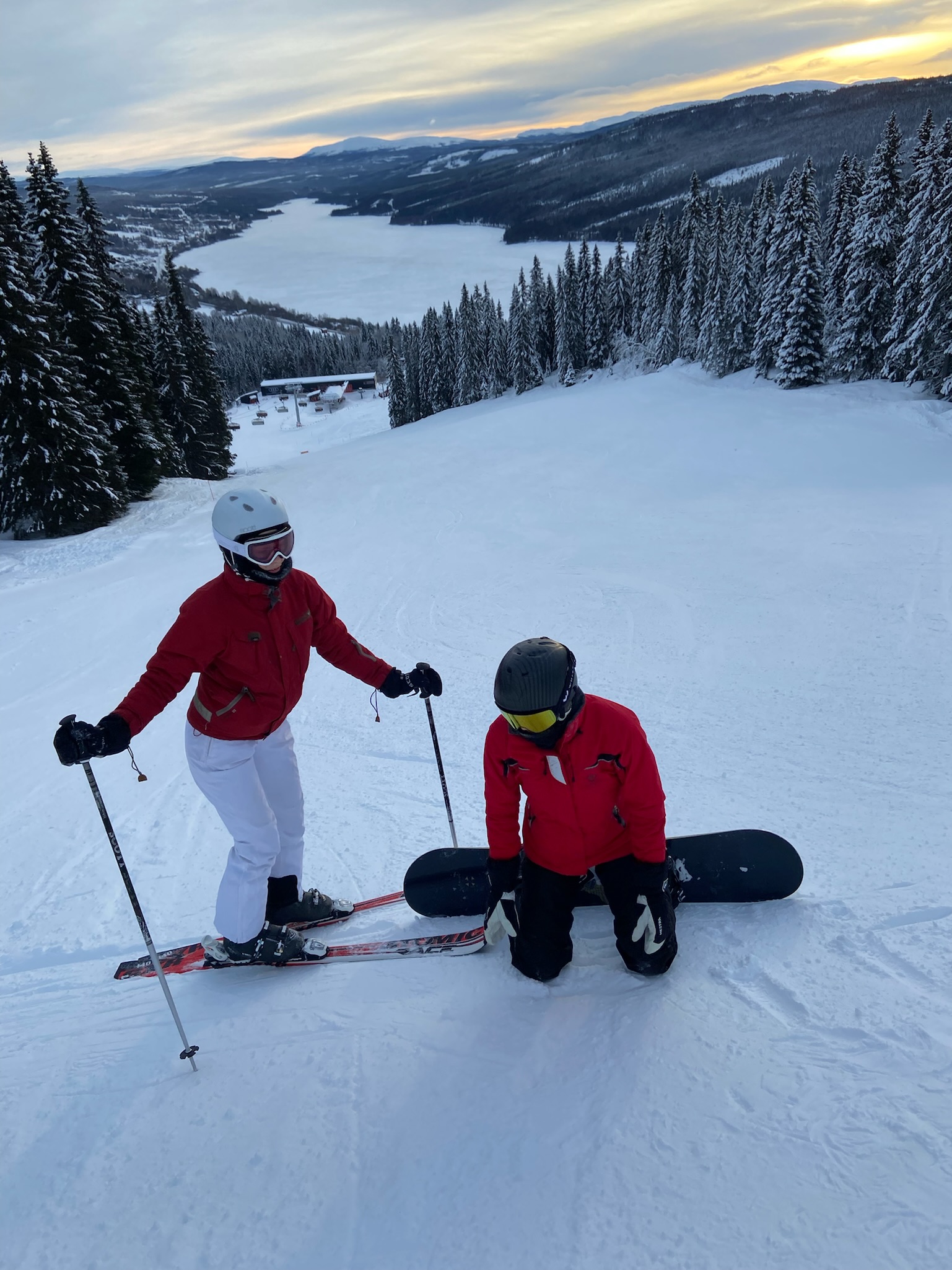 A snowboarder on a snowy slope at dusk